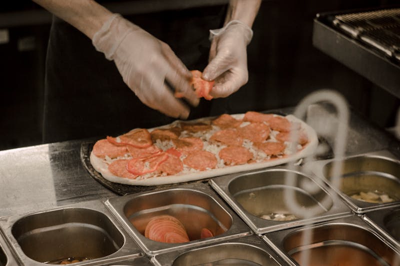 Punch pizza sous chef preparing toppings and sauces